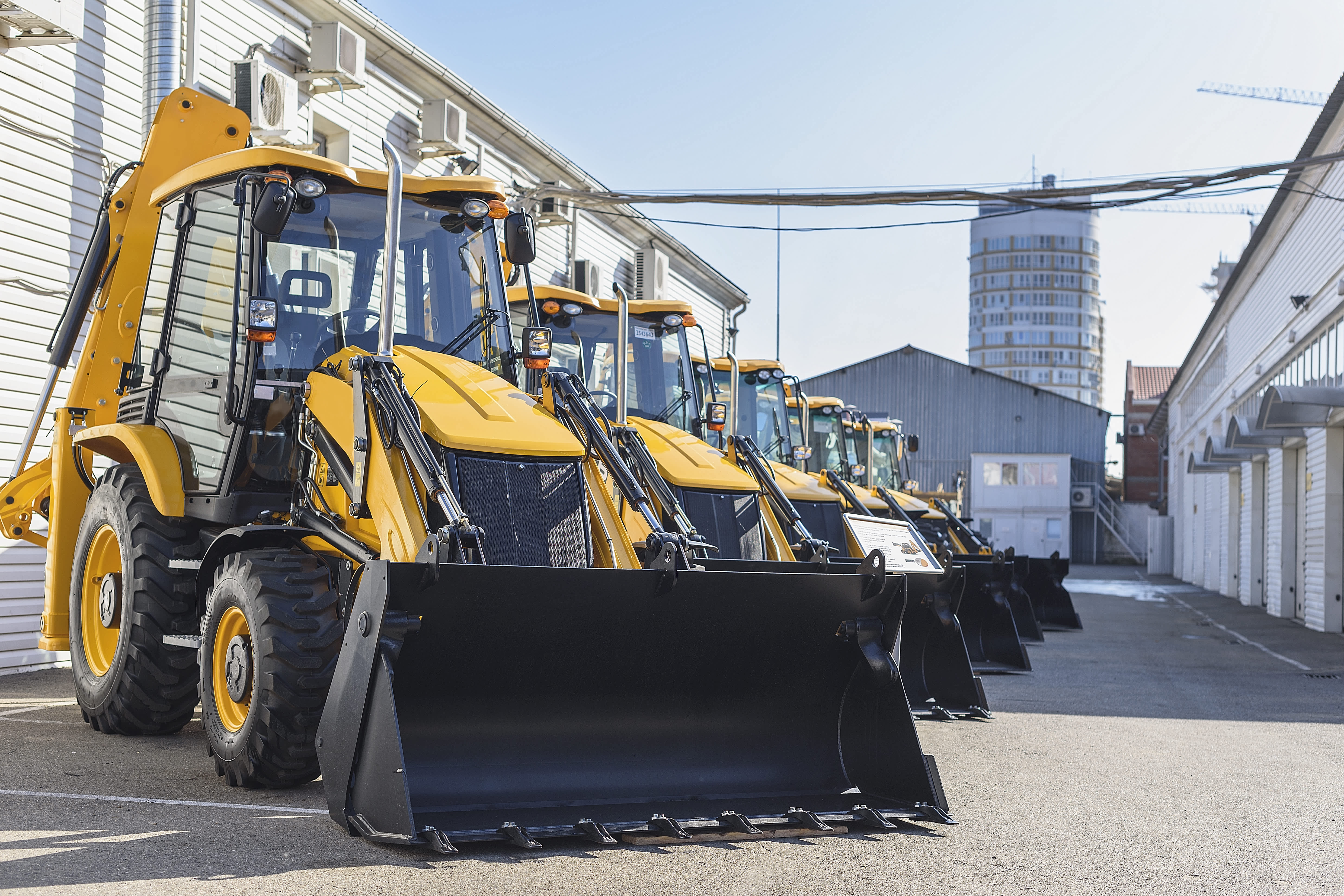 row of parked backhoe loader rentals